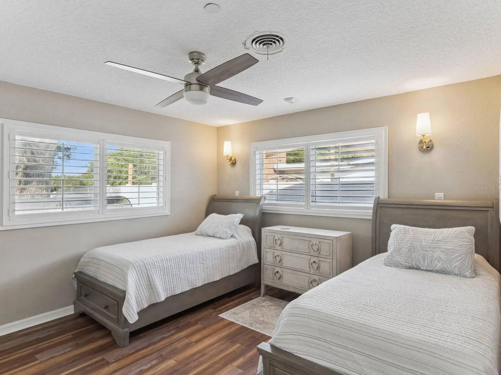 Bedroom with ceiling fan and wall sconces