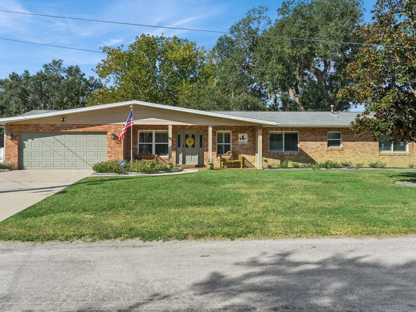 Brick home with covered front porch and mature magnolia