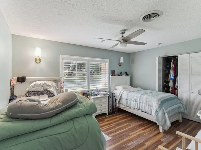 Bedroom with ceiling fan and wall sconces