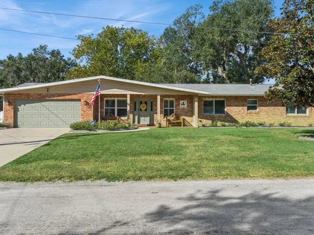 Brick home with covered front porch and mature magnolia