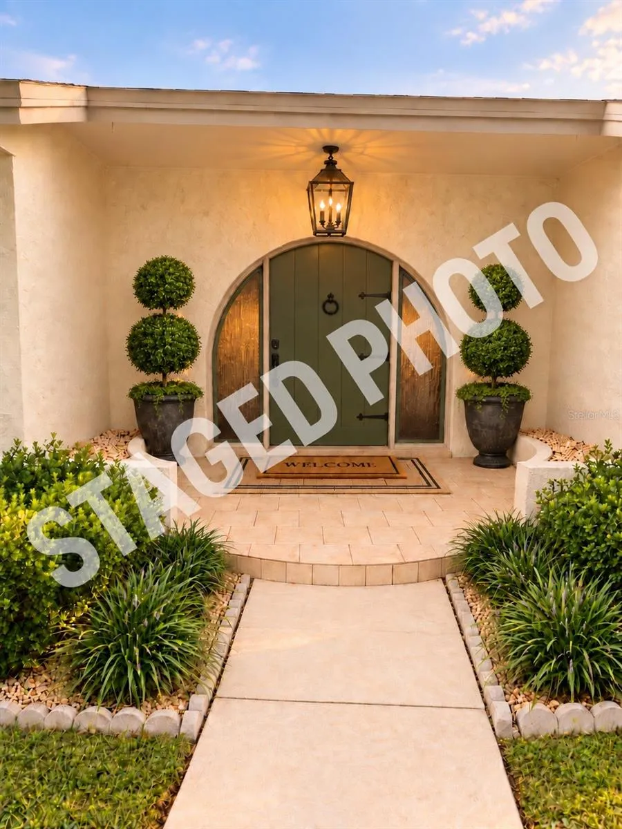 STAGED PHOTO- the only changes were painting the door switching the light for a larger one and adding the potted plants and a welcome rug! Simple updates.