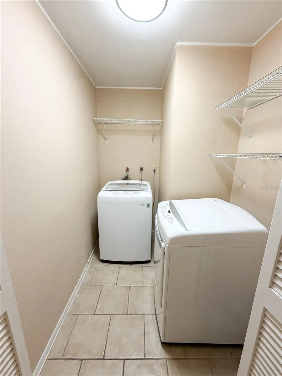 The laundry room is down the hall from the primary suite and just before you enter the garage.