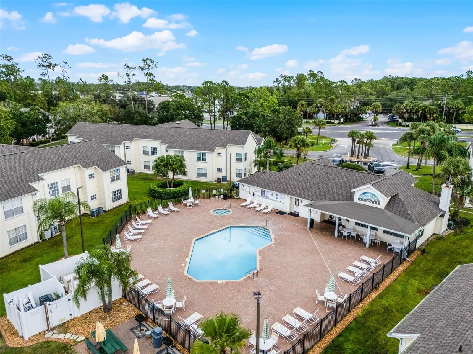 Clubhouse &amp; Pool Grounds: Aerial perspective featuring the community clubhouse, covered poolside pavilion, spacious sun deck, and surrounding residential villas