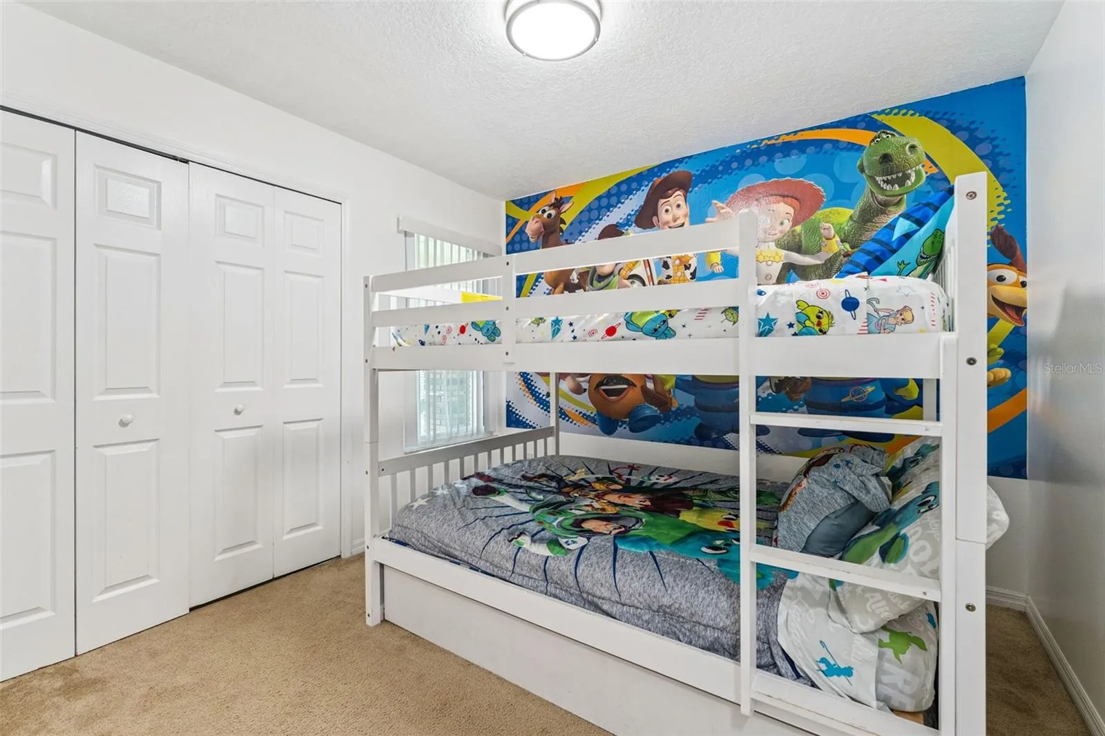 Character Bunk Room View: Alternate angle of the bunk bedroom showcasing double bi-fold closet doors and colorful themed wall graphics