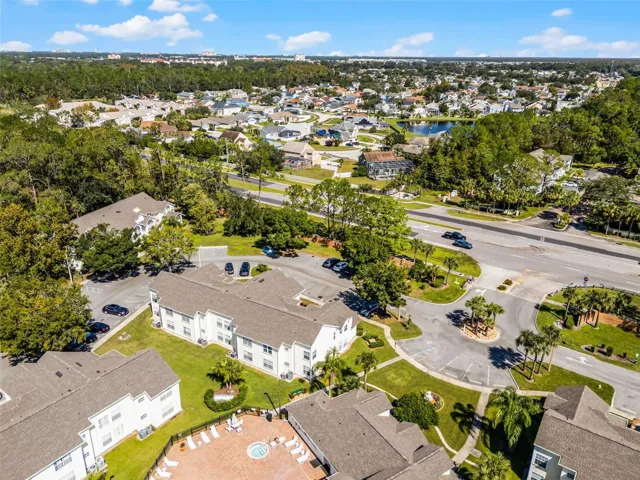 Entrance &amp; Pool Area Aerial: Aerial view highlighting the community entrance loop, ample resident parking, clubhouse pool deck, and surrounding local neighborhood.