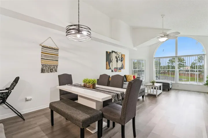 Dining Area: Dining space featuring an overhead modern chandelier fixture, dining table with bench seating, and smooth flow into the main living room.