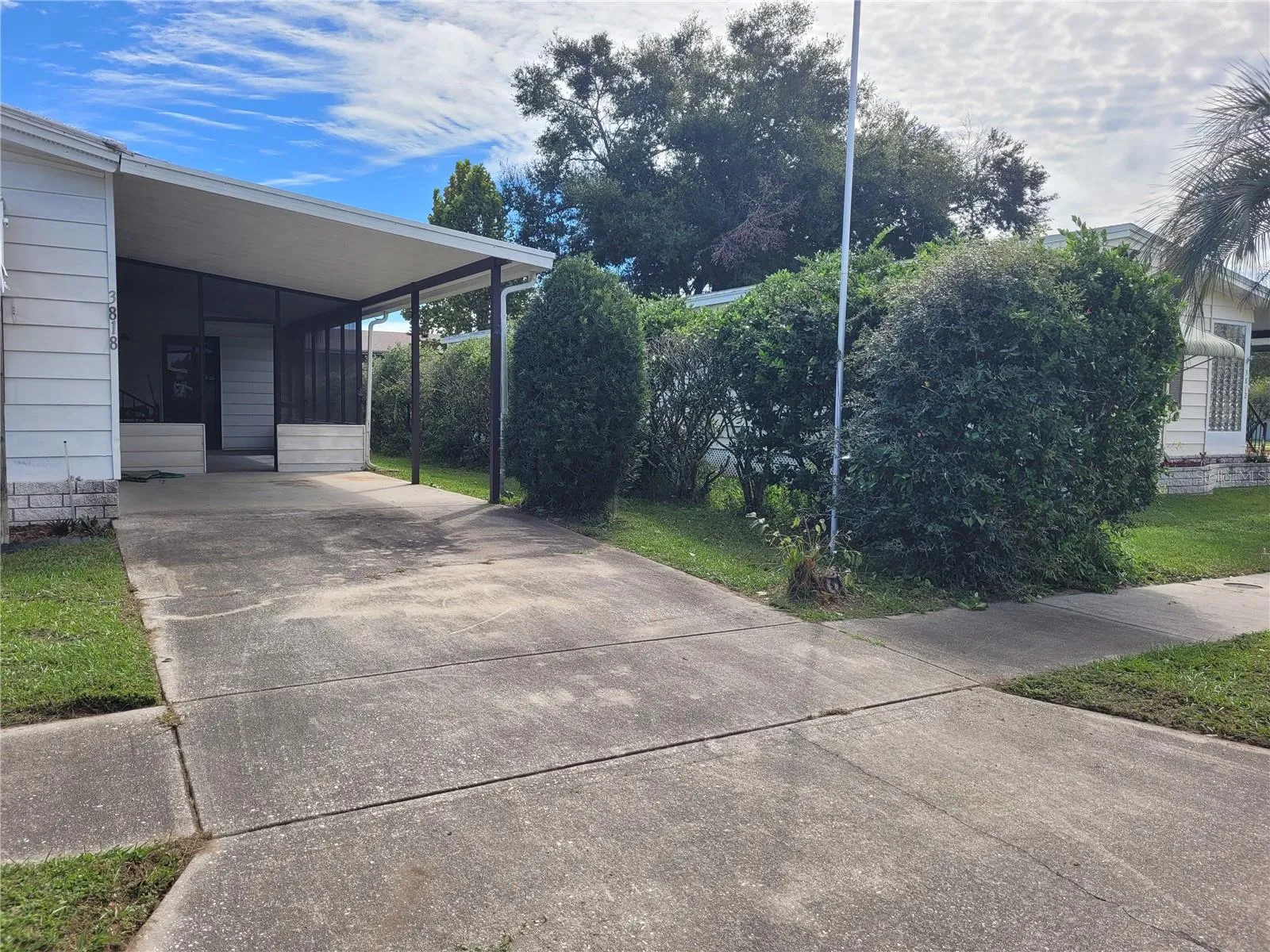 Carport showing landscaping and screen room entrance.