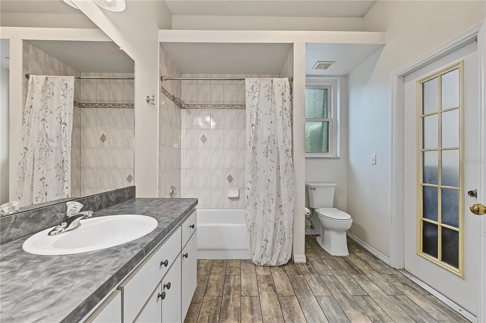 Guest Bathroom with a shower/tub, tile floors and access to the pool.
