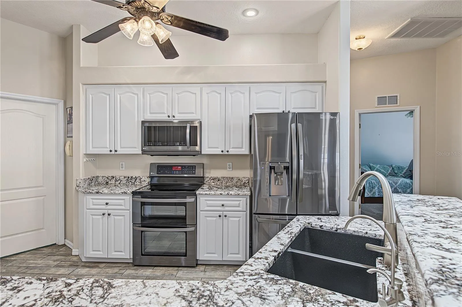 Open Kitchen, Granite Counter Tops, Inset Lights, Updated appliances, Double Oven, Ceiling Fan with lights, Tile Flooring.