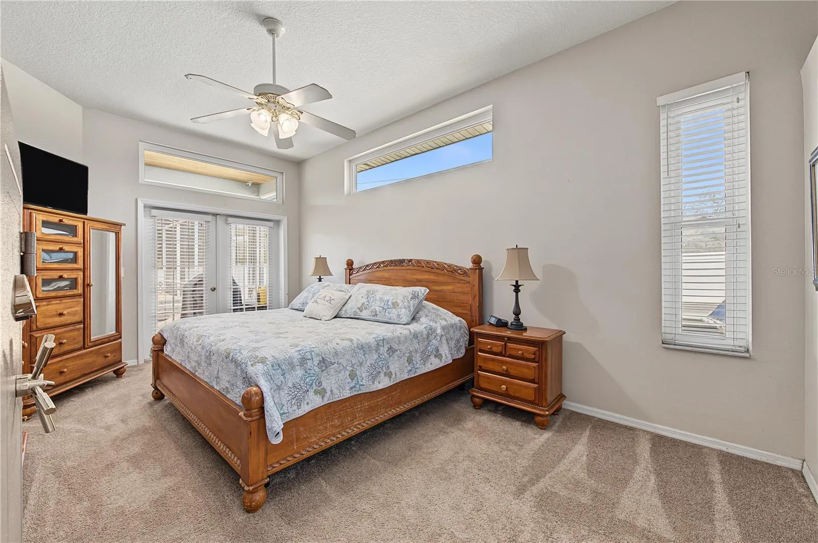 Spacious Primary Bedroom with French Doors leading out to the pool/spa/lanai.