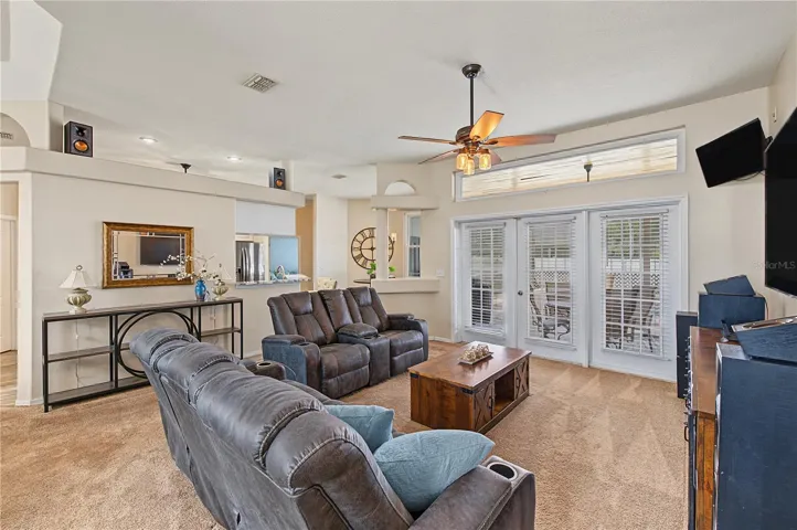 Large open great room, vaulted ceilings, French Doors leading out to the pool/lanai, ceiling fan with lights.