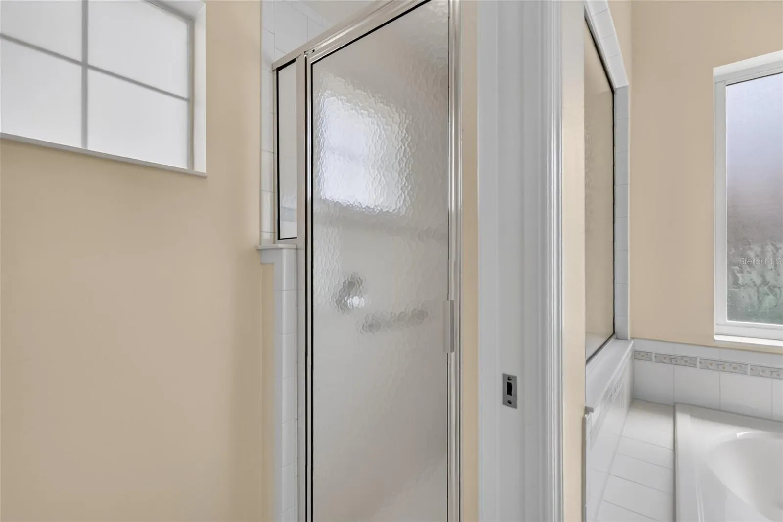 The walk in shower is separate from the tub and sink area.
