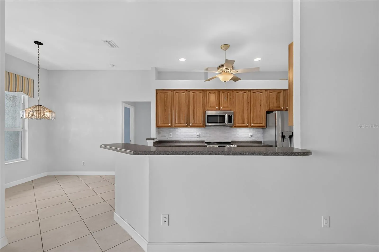 The kitchen is beautifully outfitted with oak cabinets, solid surface countertops and stainless steel appliances.