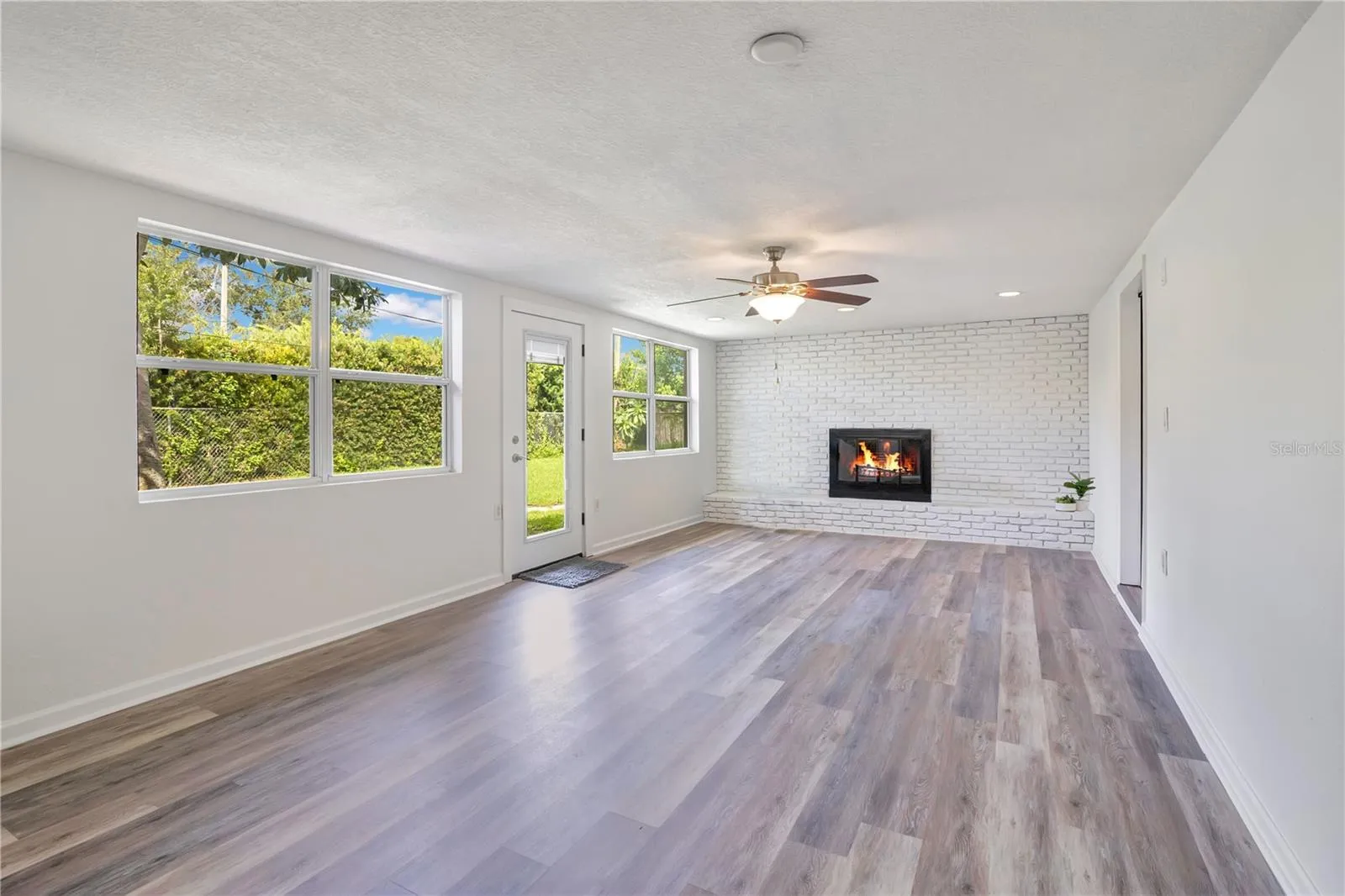 Family Room with wood-burning fireplace leading to backyard