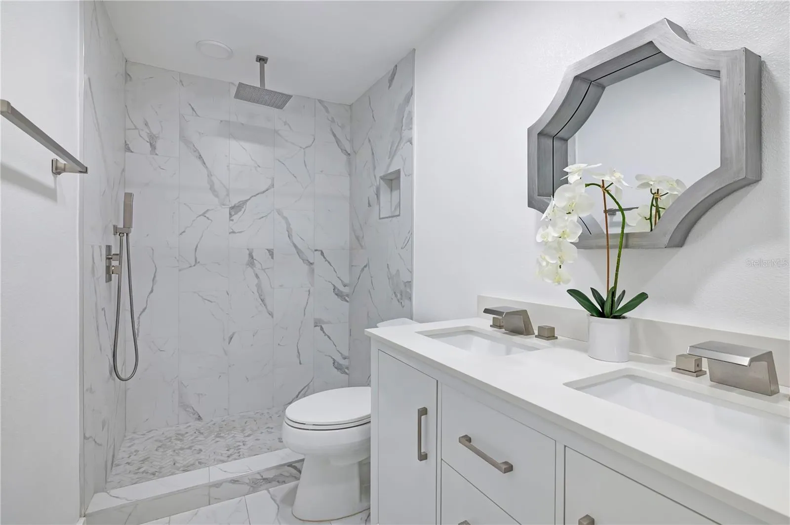 Fully renovated bathroom with double sinks and rain shower head