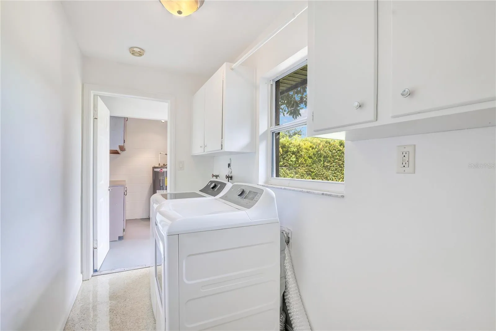 Indoor laundry room leading to workshop in garage