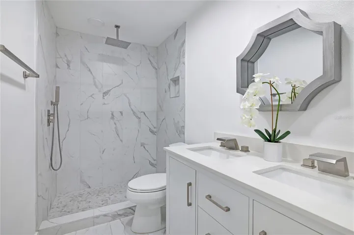 Fully renovated bathroom with double sinks and rain shower head