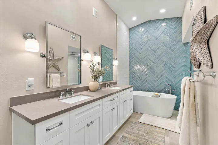 Beautifully updated primary bath featuring a freestanding soaking tub and elegant modern finishes.