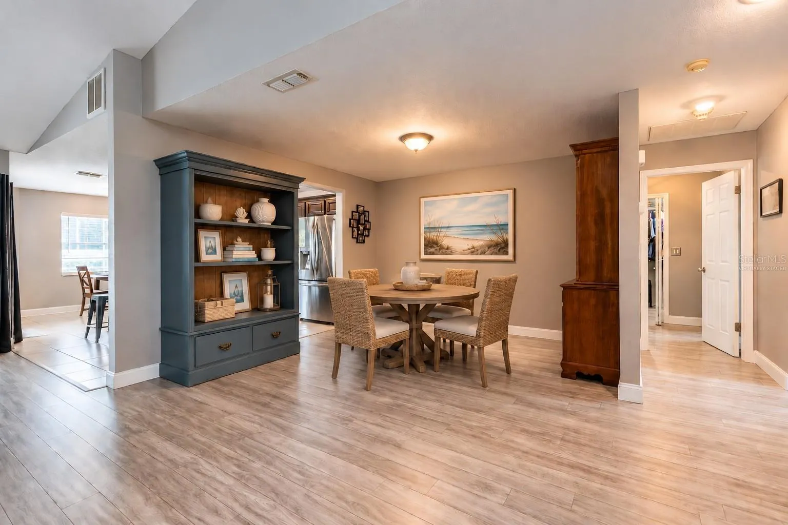 Virtually staged dining area off of the great room, kitchen and the hall leads to the laundry room and secondary bedrooms.