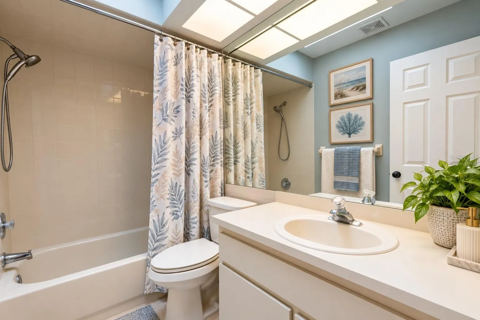 Bathroom shared by second and third bedrooms with virtually staged decor.