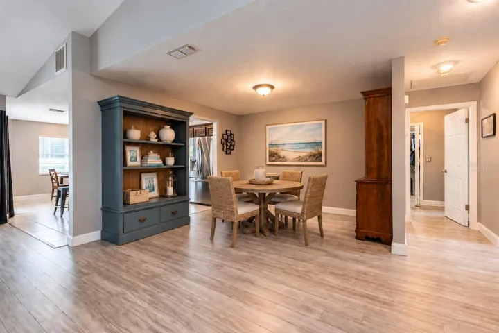 Virtually staged dining area off of the great room, kitchen and the hall leads to the laundry room and secondary bedrooms.