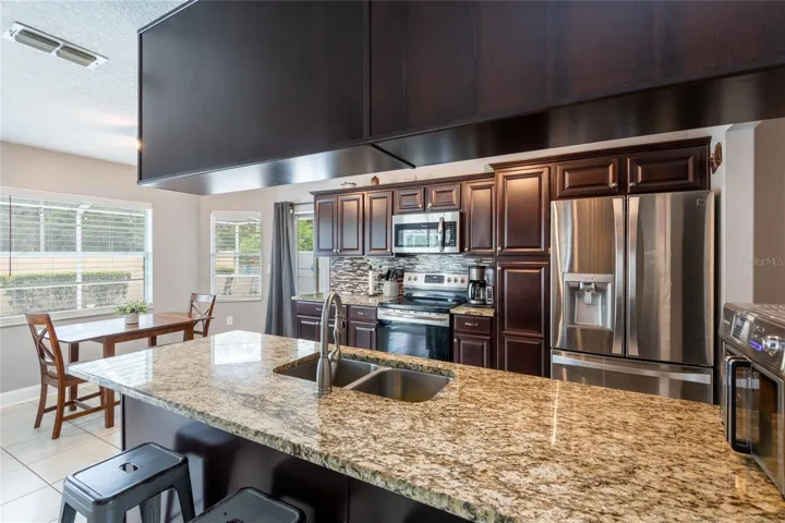 Kitchen and dinette with granite counter tops and wood cabints.