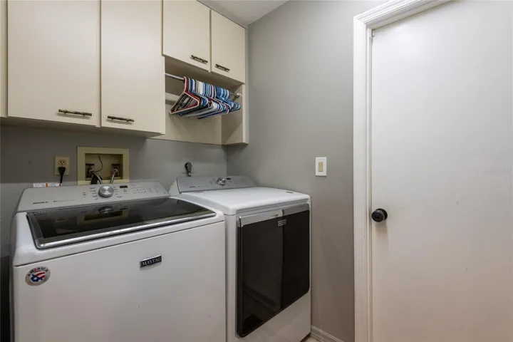 Laundry room with storage cabinets that lead to the garage.