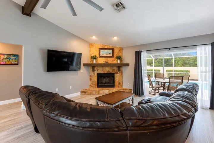Great room with a wood burning fireplace and the sliding doors are recessed open to bring the inside and outside together.