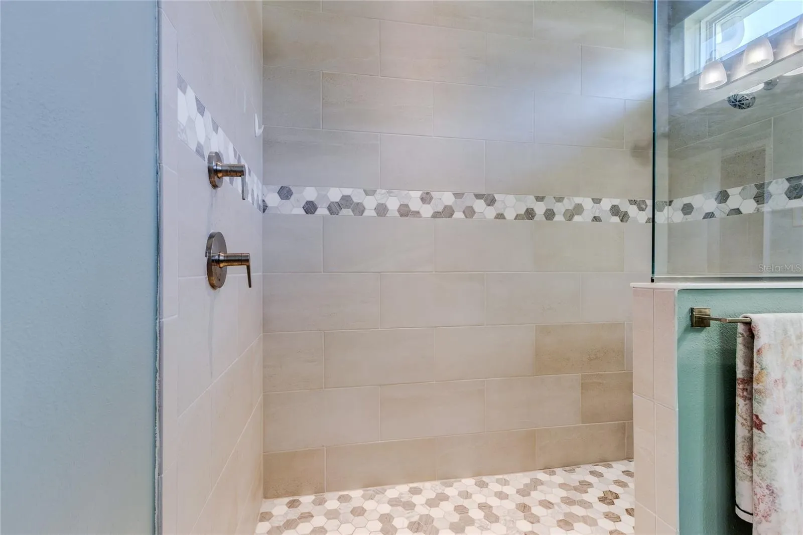 Stone accent band in walk in shower