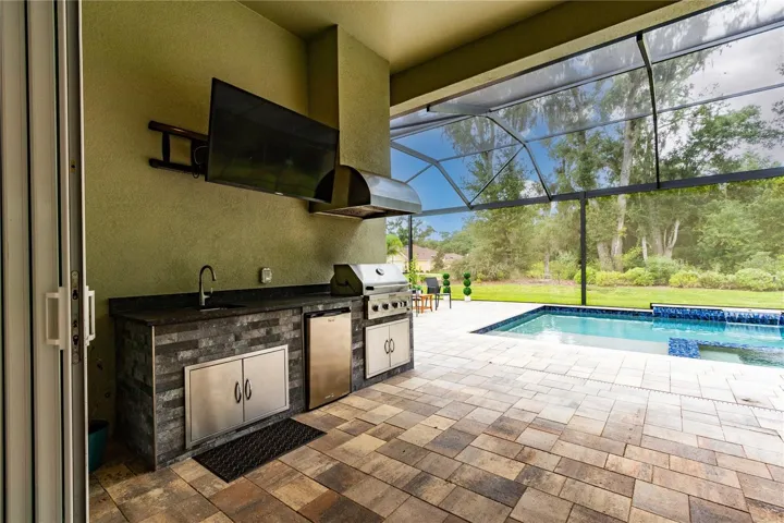 Outdoor kitchen boasts Kitchenaid grill, fridge and sink