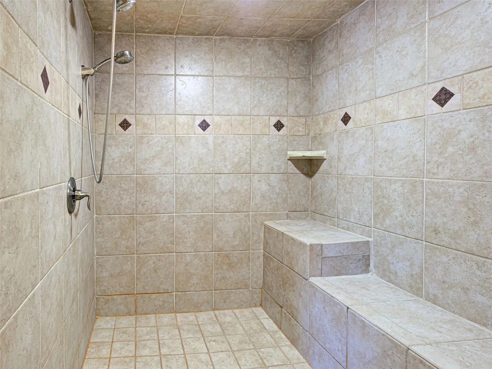 The primary shower is tastefully tiled and oversized.