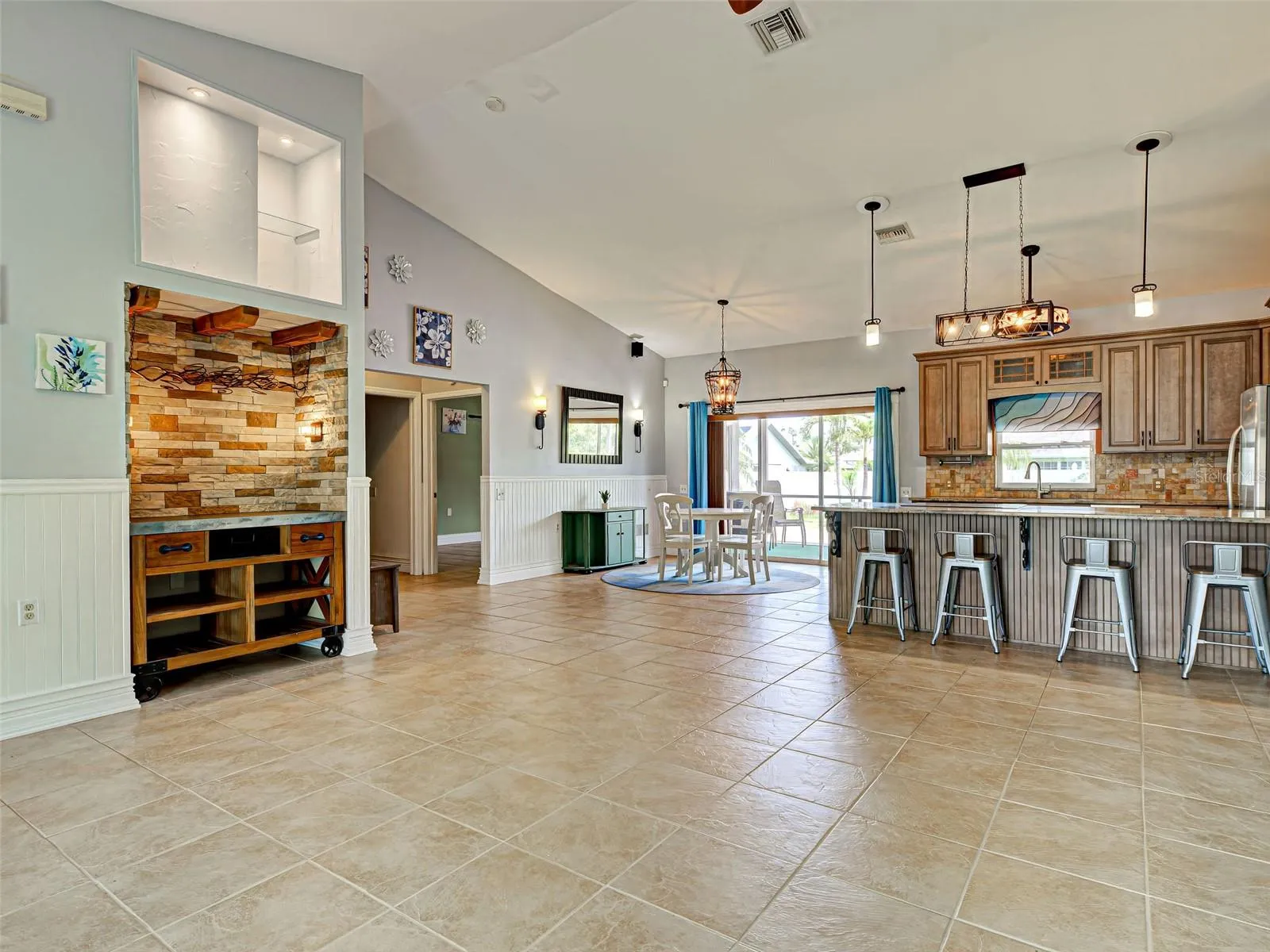 The dining area is steps away from the kitchen and has access to the lanai through the sliding glass doors.  Look at the beautiful light fixtures.