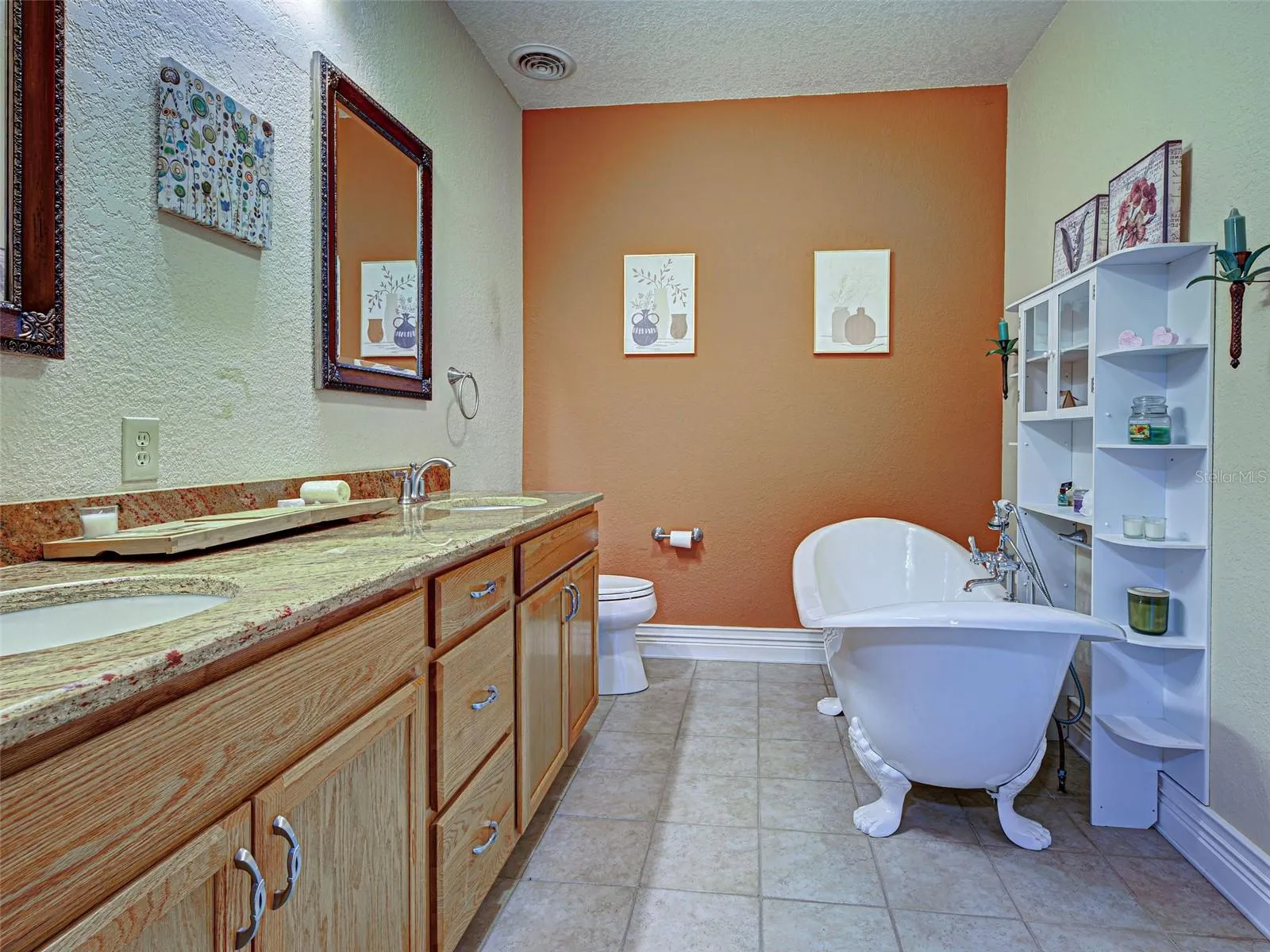 The primary bathroom has dual sinks, stone countertops and a beautiful clawfoot tub.