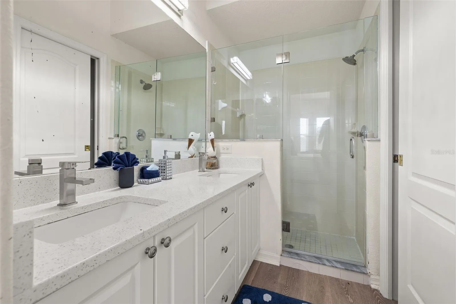 Primary bathroom with walk in shower and dual vanities
