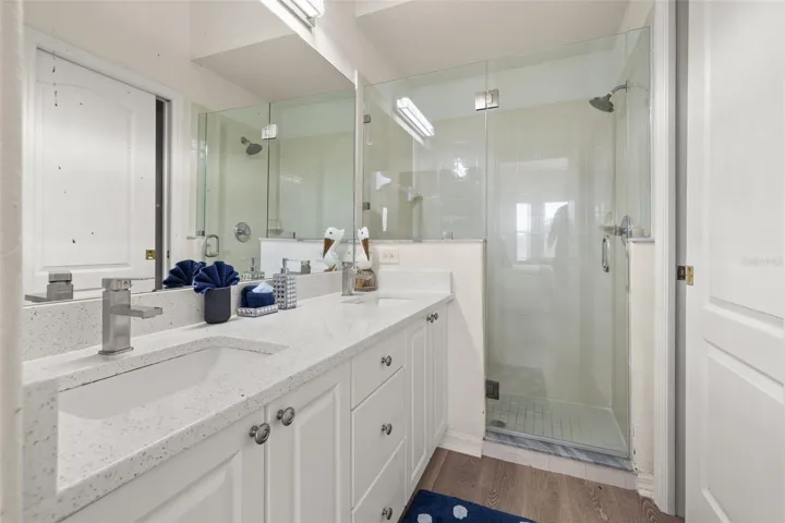 Primary bathroom with walk in shower and dual vanities