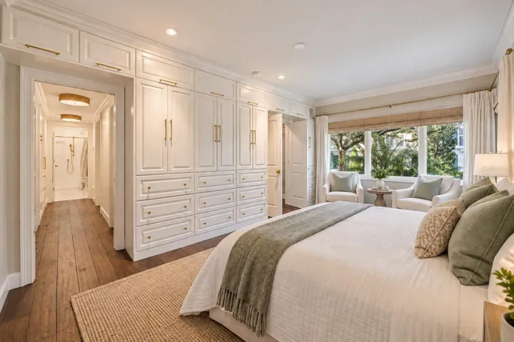 Wall of built-ins in primary bedroom *virtually staged