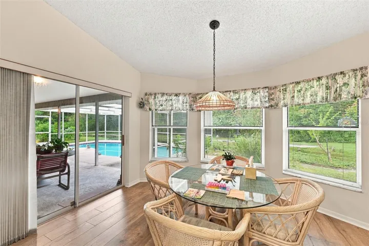 Kitchen nook with view of bird feeder, flower garden, access to pool area