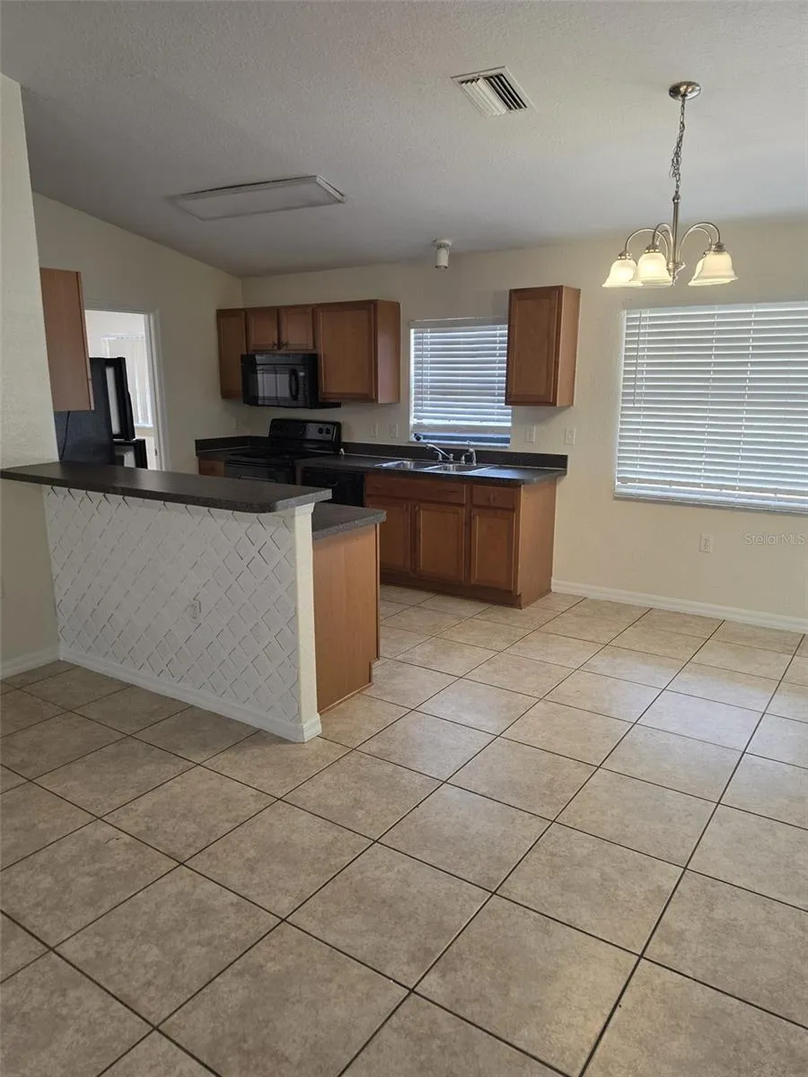 Kitchen with breakfast bar, range, microwave, dishwasher and refrigerator
