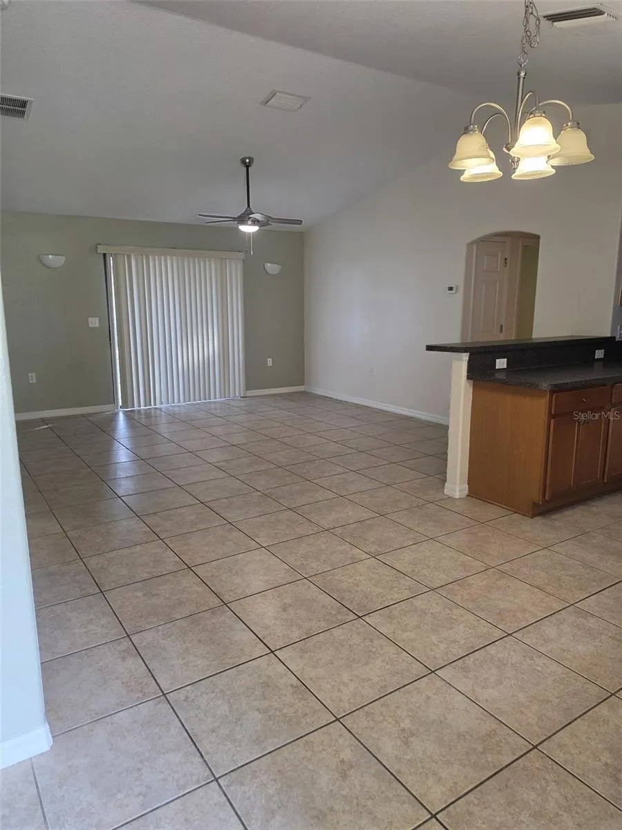 Great room with tile floors, ceiling fan and sliding door to the patio