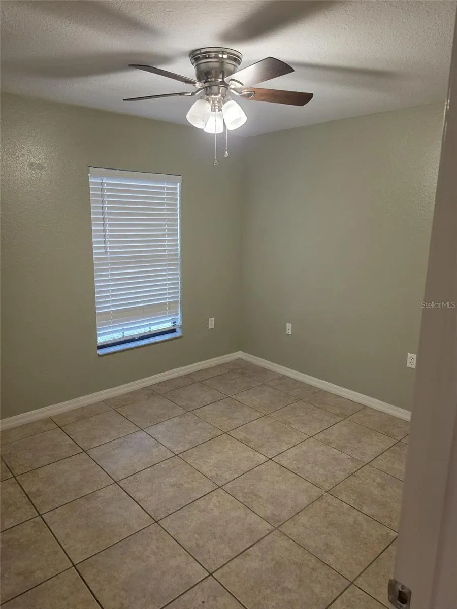 Second bedroom with tile floors and ceiling fan