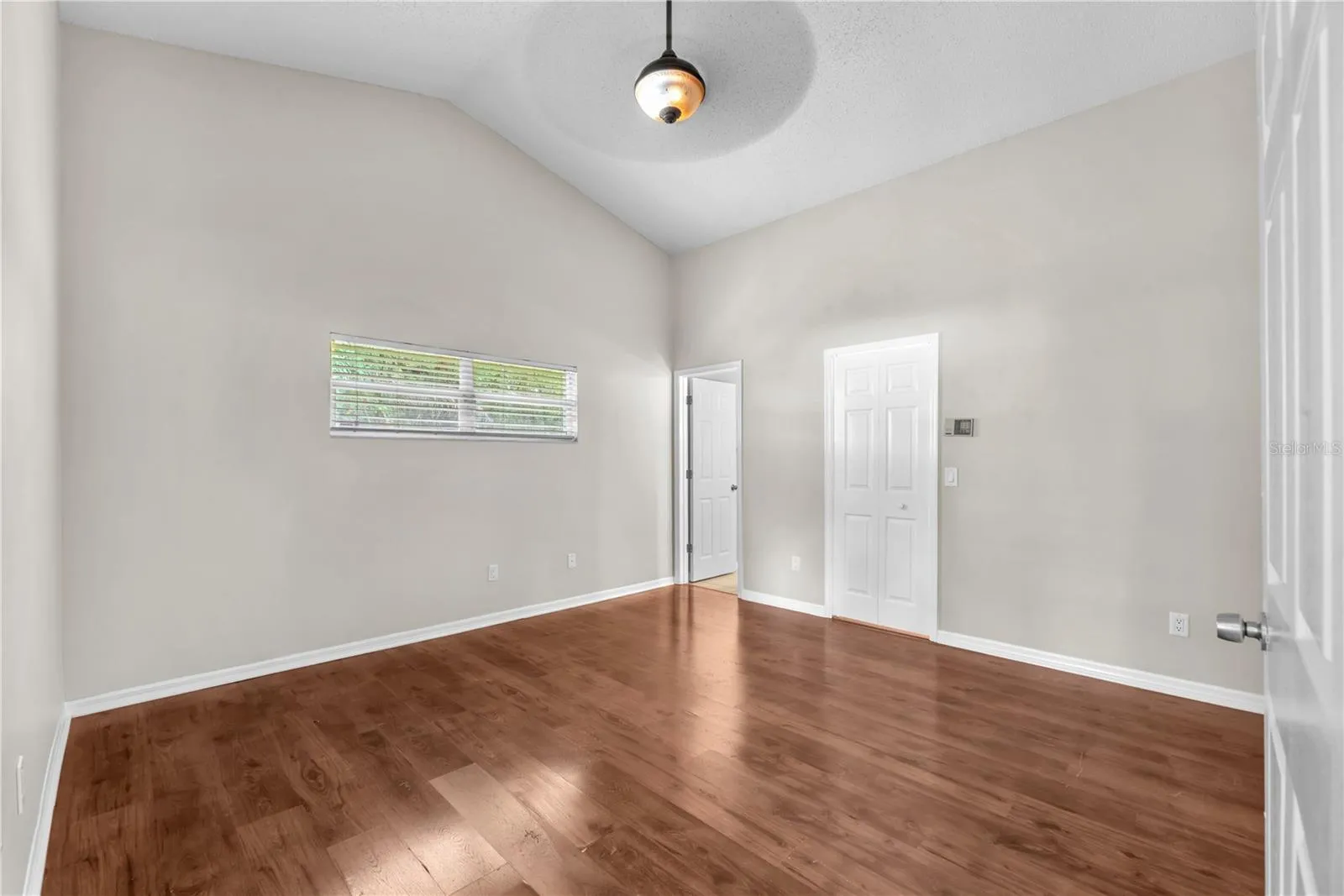 The primary bedroom has an en suite bath and walk in closet.  Notice the transom window that lets in natural light but high enough for easy furniture placement.