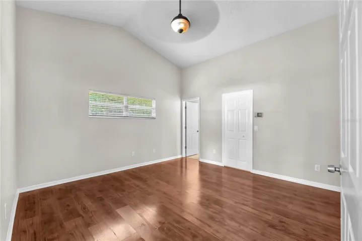 The primary bedroom has an en suite bath and walk in closet.  Notice the transom window that lets in natural light but high enough for easy furniture placement.