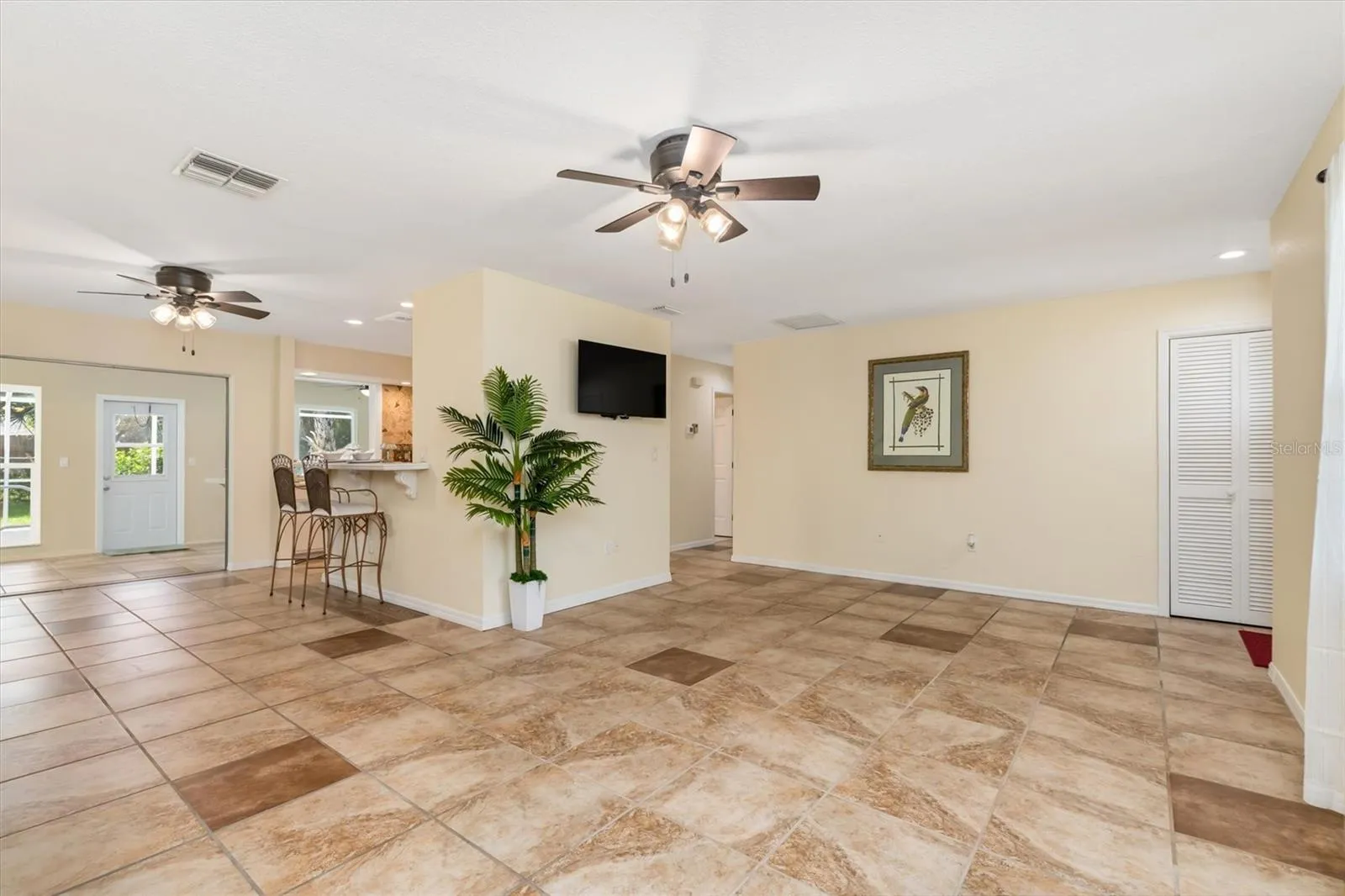 Showing off living room on right, kitchen center and dining area on left