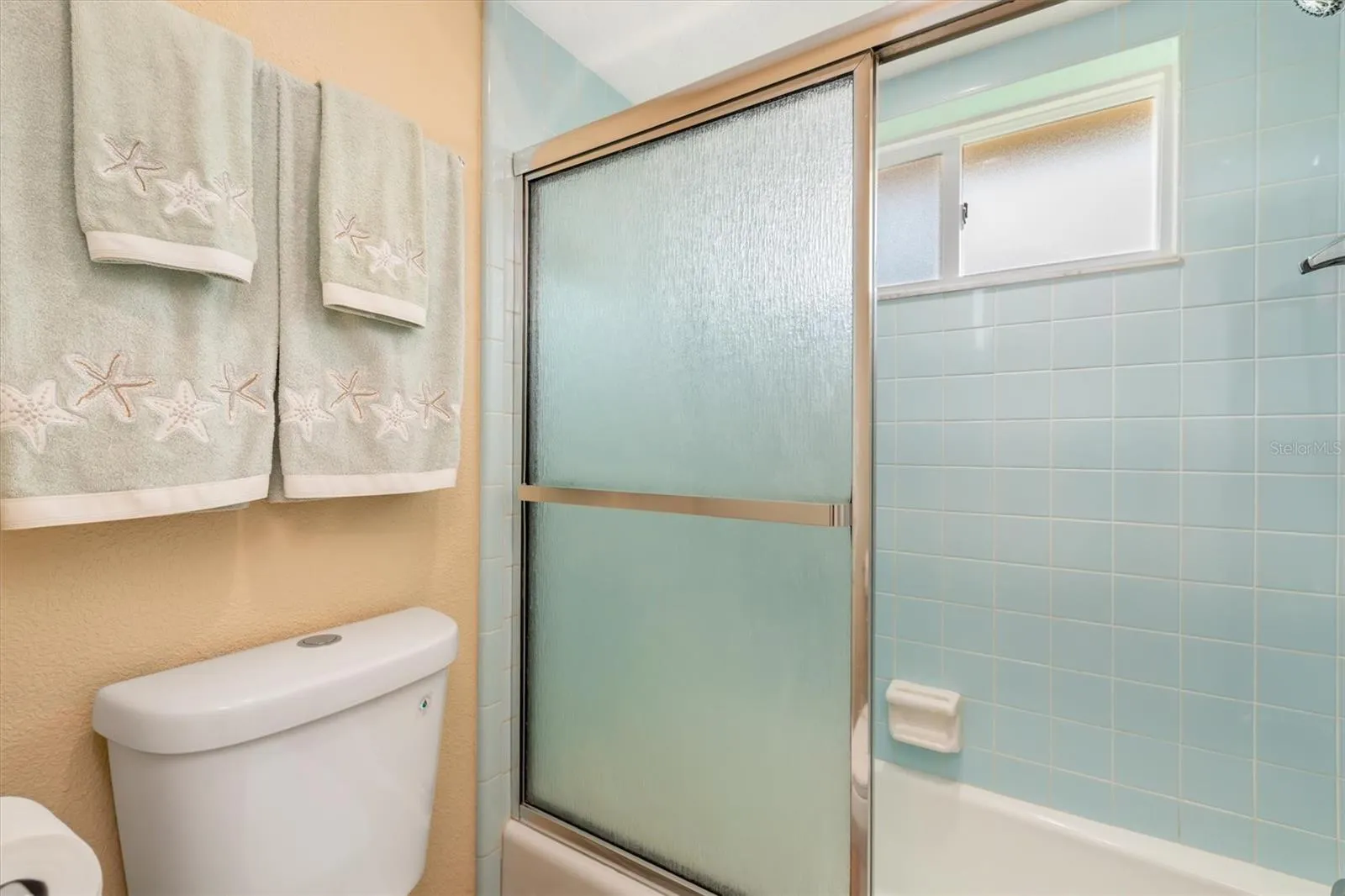 tub/shower in primary with beautiful retro tile