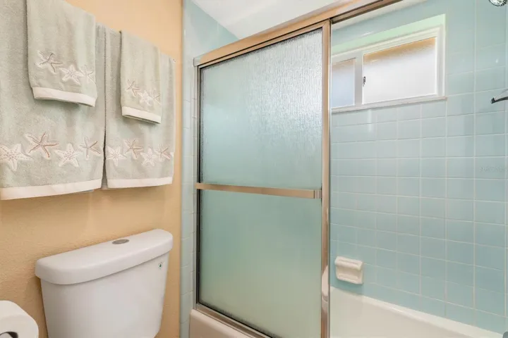 tub/shower in primary with beautiful retro tile