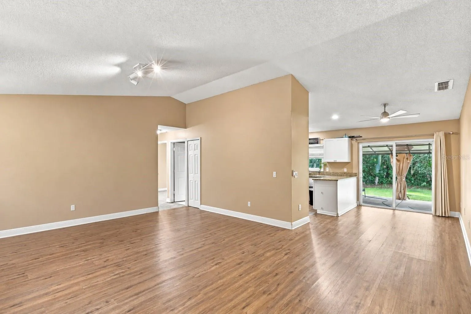Great room with access to kitchen and patio access.