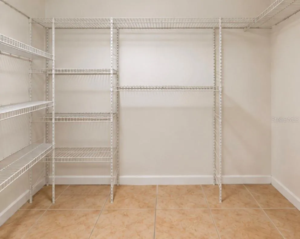 Spacious walk-in closet with added shelving.