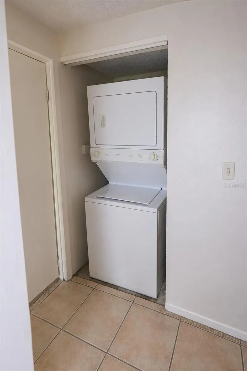Stacked washer and dryer in laundry closet.
