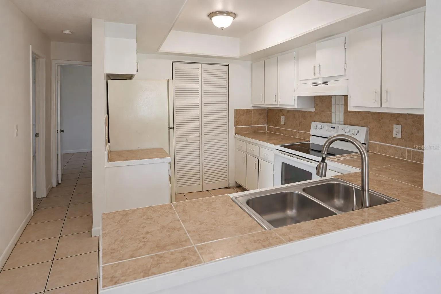 Kitchen with pantry and opening from dining area.  Bedrooms at left.