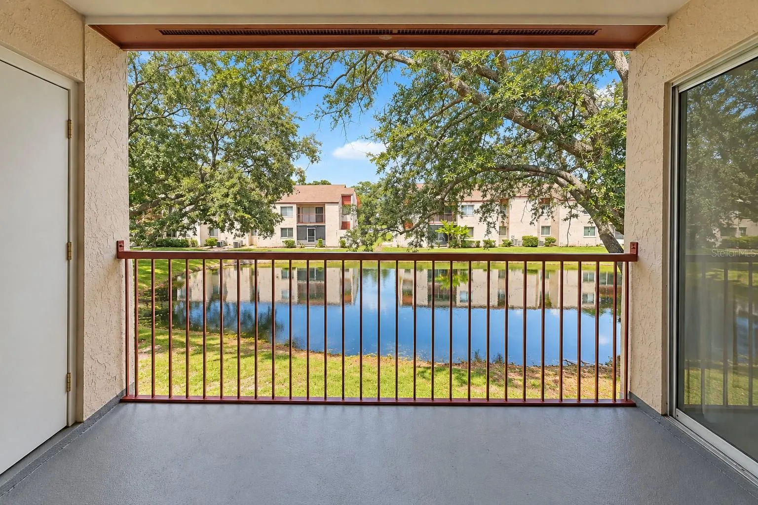 Tranquil pond view from balcony.  Exterior storage room at left.